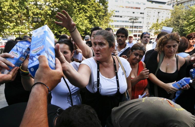 Members of Greece's far right Golden Dawn party hand out boxes of milk to residents suffering from the economic crisis at the Syntagma square in Athens on Aug. 1, 2012.