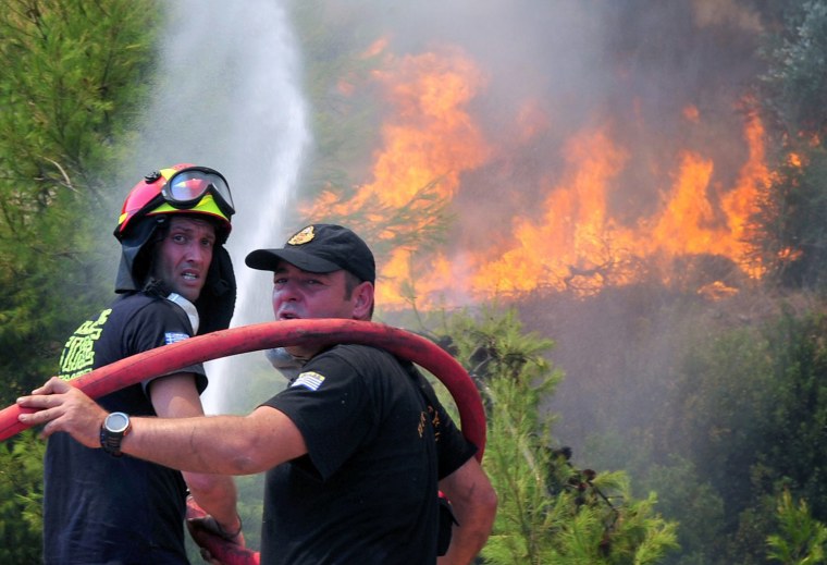 Firemen try to extinguish forest fires on the mountain of Spathovouni, near Corinth city, Peloponnese, southern Greece, on August 8.