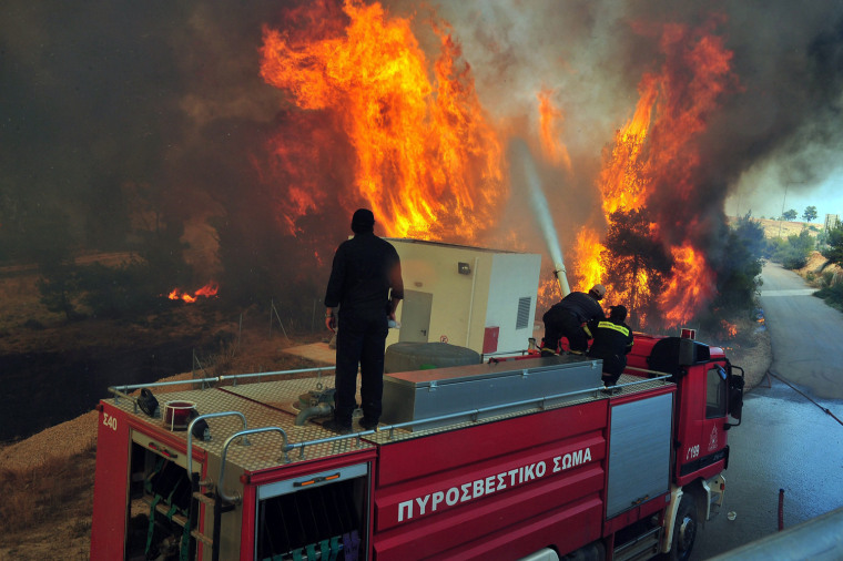 Firemen try to extinguish a forest fire on the mountain of Spathovouni, near Corinth city, Peloponnese, southern Greece, on August 8.