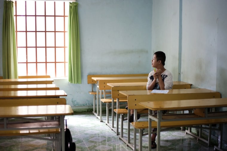 Chu Thanh Nhan, 12, sits in an empty classroom at a rehabilitation center in Danang, Vietnam. The children were born with physical and mental disabilities that the center's director says were caused by their parents' exposure to the chemical dioxin in the defoliant Agent Orange.