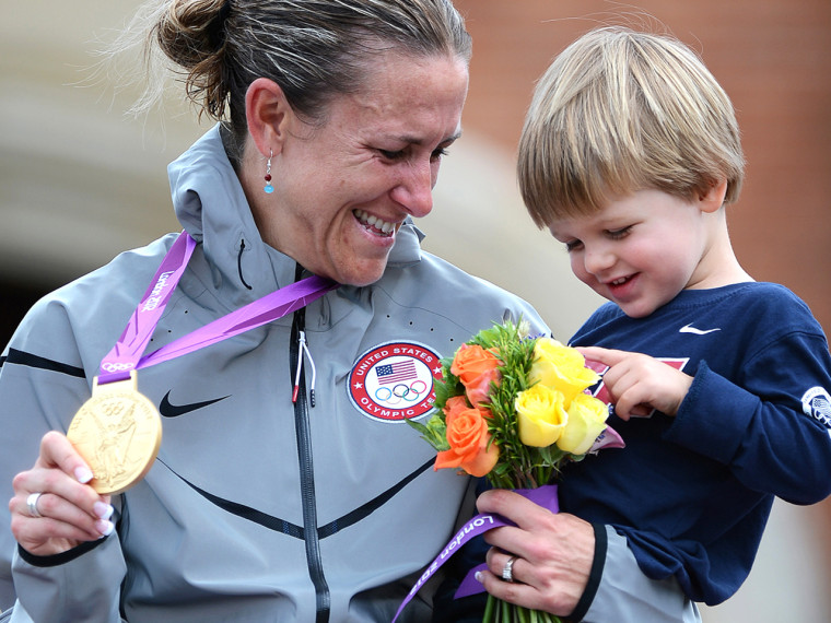 US gold medalist Kristin Armstrong holds her son as she stands on the podium after winning the London 2012 Olympic Games women's individual time trial road cycling event.