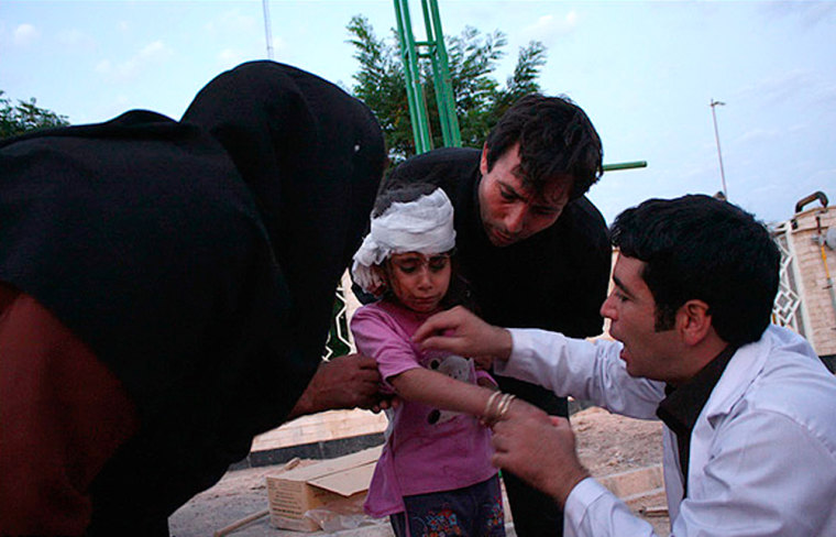 A doctor looks at wounds on an earthquake victim in this undated handout photo taken in an undisclosed location in northwest Iran.