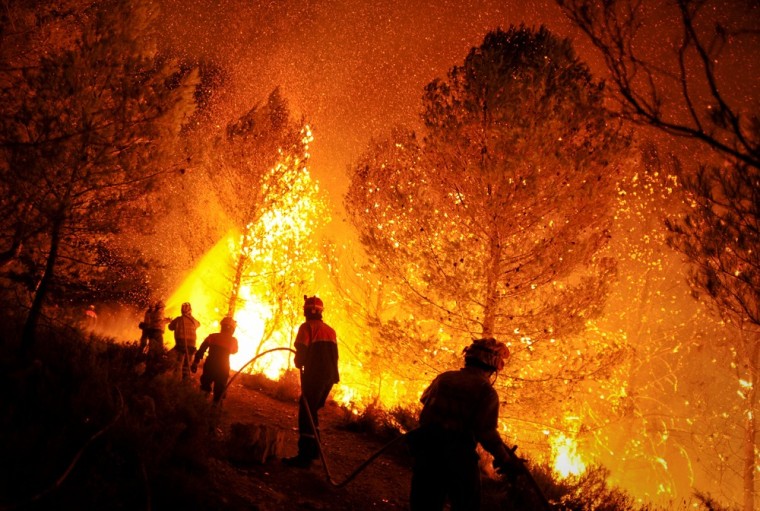 Firefighters try to extinguish a fire in Torre de Macanes near Alicante on August 13, 2012.