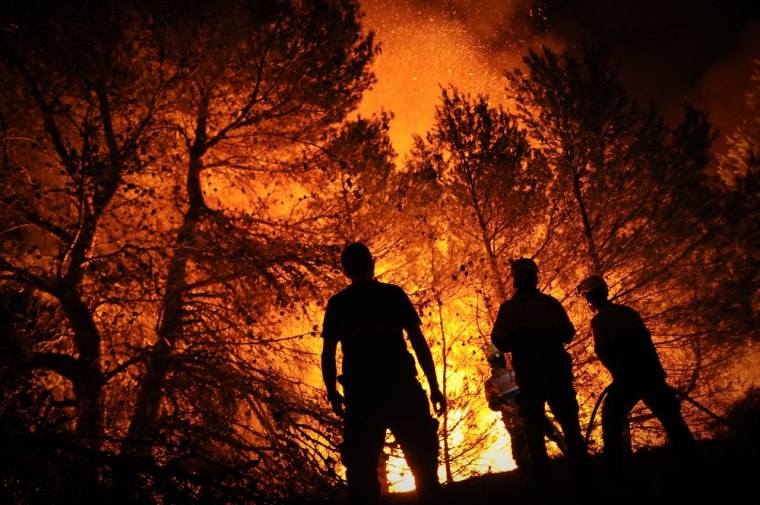 Firefighters battle a fire in Torre de Macanes near Alicante on August 13, 2012.