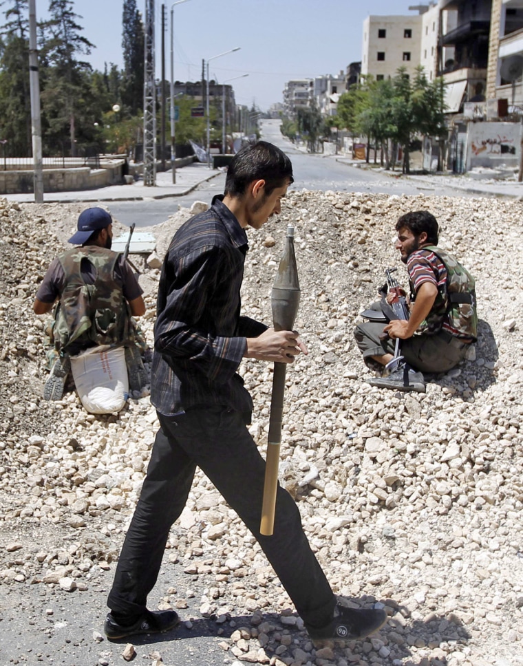 Free Syrian Army fighters sit behind a barricade in Aleppo on Aug. 13.