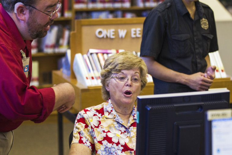 Librarian Josh Soule speaks with Rosalind Licht as she reacts to lessons on how to set up and use a Facebook account at a branch of the New York Public Library in New York on Aug. 13, 2012.