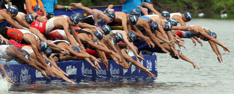Competitors dive into the water at the start of the men's elite race at the Hy-Vee Triathlon on Sunday, June 13, 2010, in West Des Moines, Iowa.