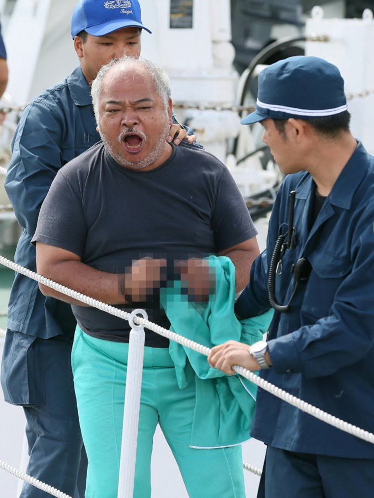 A Hong Kong man one of the pro-China activists that landed on the disputed island known as Senkaku in Japan and Diaoyu in China. EDITORS NOTE---- HANDCUFFS HAVE BEEN PIXELATED BY SOURCE JIJI PRESS