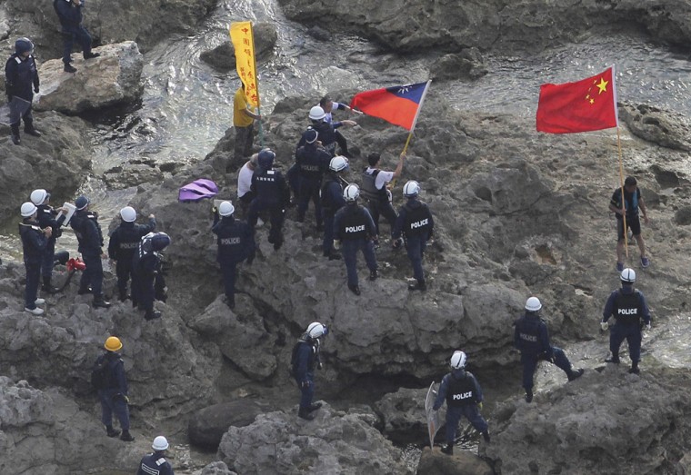 Activists holding Chinese and Taiwanese flags are arrested by Japanese police officers after landing on Uotsuri Island on Wednesday.