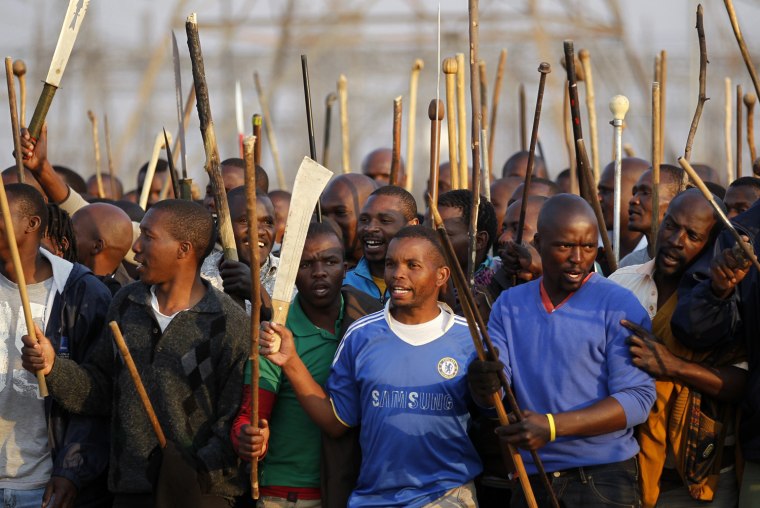 Striking miners chant slogans outside a South African mine in Rustenburg on Aug. 15, 2012. Thousands of striking miners armed with machetes and sticks faced off with South African police on Wednesday at Lonmin's Marikana mine after it halted production following the deaths of 10 people in fighting between rival unions. Lonmin, the world's third-largest platinum producer, has threatened to sack 3,000 rock drill operators if they fail to end a wildcat pay strike that started on Friday at Marikana, its flagship mine.