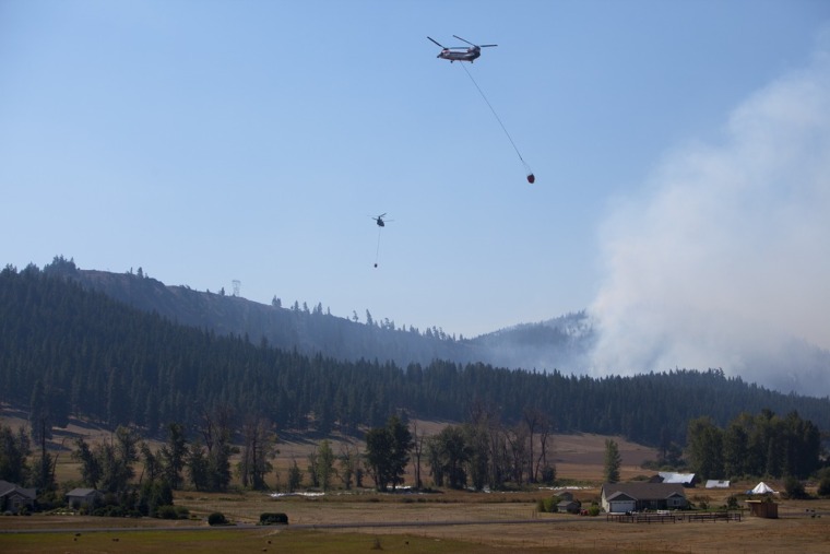 Helicopters drop water on the Taylor Bridge Fire just east of Cle Elum, Wash., Thursday, Aug. 16.