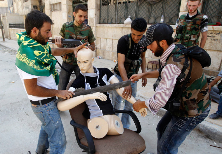 Free Syrian Army fighters dress a mannequin to looks like a fighter during clashes in the Salaheddine neighborhood of central Aleppo on Aug. 17.