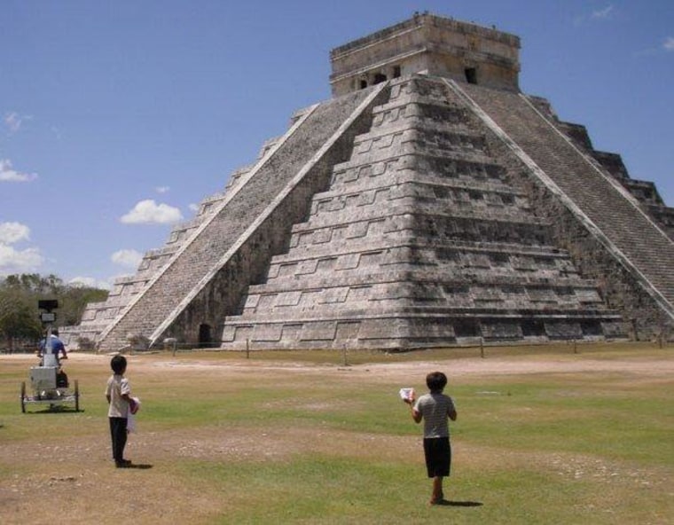 Children watch as a rider drives a camera-equipped tricycle around a temple at the Chichen Itza archaeological site in the Mexico's Yucatan state. Imagery from the tricycle trip has been incorporated into Google Street View.