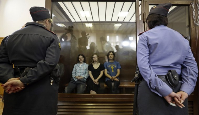 Feminist punk group Pussy Riot members, from left, Yekaterina Samutsevich, Maria Alekhina and Nadezhda Tolokonnikova sit in a glass cage at a court room in Moscow, Russia on Friday, Aug. 17, 2012.