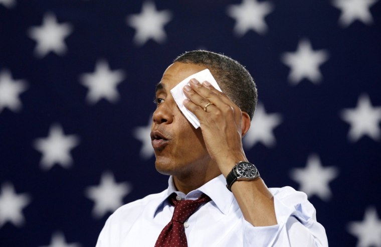 President Barack Obama wipes perspiration from his face as he speaks Saturday in a sweltering gym during a campaign stop at Windham High School in Windham, N.H.