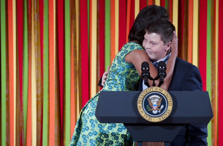 US First Lady Michelle Obama hugs her introducer, 12-year-old Marshall Reid from North Carolina and author of