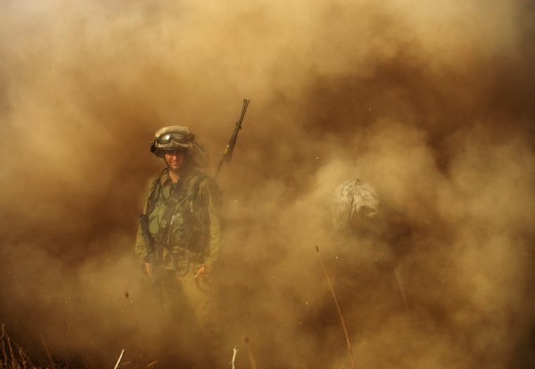 An Israeli soldier is seen in the dust during a military exercise in the Golan Heights, northern Israel, on August 21, 2012. Israeli Armed Forces have been conducting manoeuvers amid rising tensions in the region.