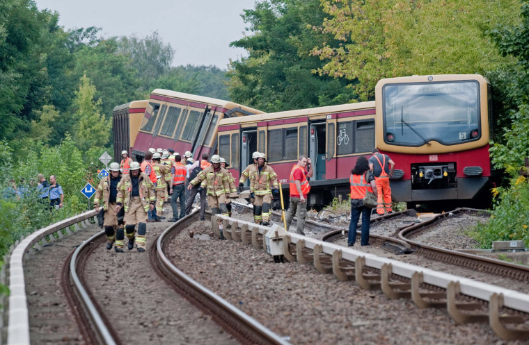 Firemen and policemen investigate the scene where Berlin city train (S-Bahn) derailed, Aug. 21, 2012. Five people were injured as the train derailed between the Tegel and Schulzendorf train stations.