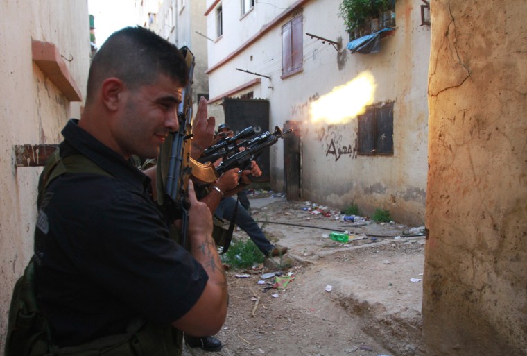 Sunni Muslim gunmen fire their weapons in the Sunni Muslim dominant neighborhood of Bab al-Tebbaneh in Tripoli, northern Lebanon, during clashes with Alawites, Aug. 21.