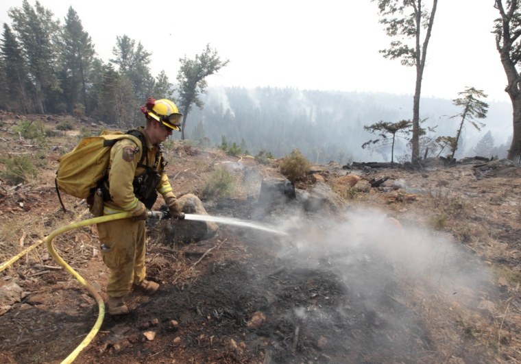 Firefighter Josh Gillick hoses down a hot spot of the Ponderosa Fire near Viola, Calif. on Monday, Aug. 20.