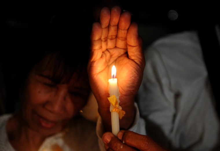 Women light candles after a mass for Department of Interior and Local Government (DILG) Secretary Jesse Robredo at the Saint Peter's Church in Manila on Aug. 21. The Philippines was in mourning after divers recovered the body of one of its most influential politicians, who died when a plane carrying him and three others crashed into the sea.