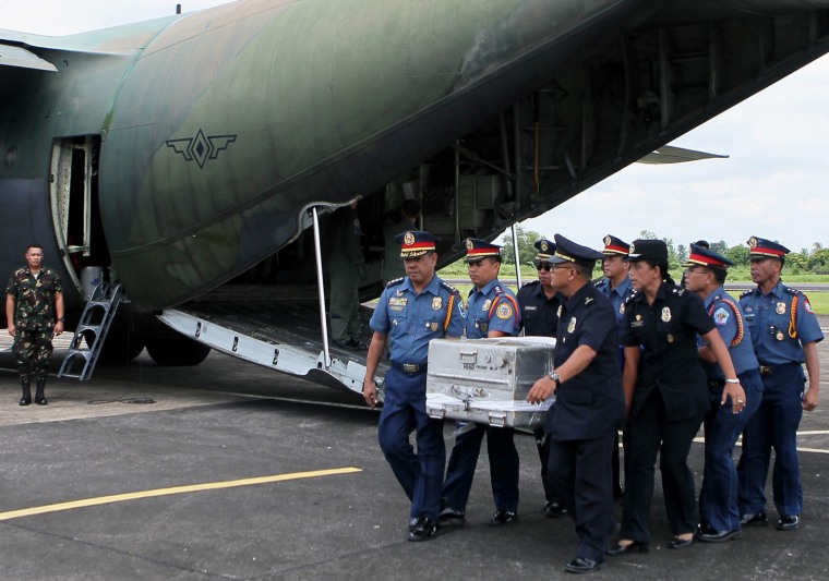 Police and other local government officials carry the remains of Interior Minister Jesse Robredo from a military plane at the Naga Airport, Camarines Sur province, eastern Philippines, Aug. 21.