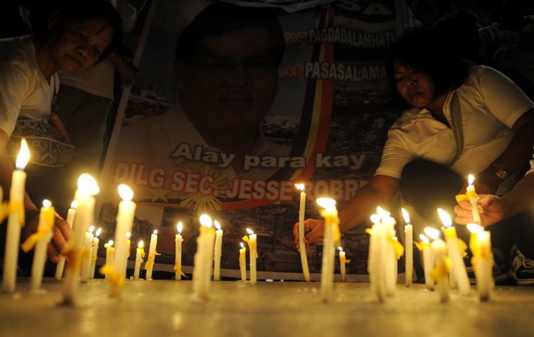 Women light candles after a mass for Department of Interior and Local Government (DILG) Secretary Jesse Robredo at the Saint Peter's Church in Manila on Aug. 21.