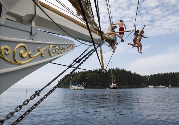 Olivia Trankina of Marietta, Ga., and Liz Archibald of Clarks Summit, Penn., leap from the bowsprit of the schooner Mary Day in Bucks Harbor in South Brooksville, Maine.