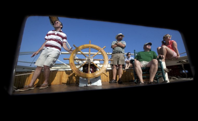Passenger Paul Ernest of Lynnfield, Mass., left, takes a turn at the helm during a three-day cruise on the schooner Mary Day on Penobscot Bay off Camden, Maine.