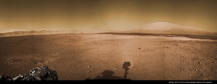 A colorized view of the Curiosity rover's surroundings draws upon navigation camera imagery, with the Martian sky filled in.