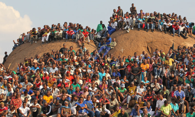 Mourners at a memorial service at the Lonmin Platinum Mine near Rustenburg, South Africa, Aug. 23, crowd onto the
