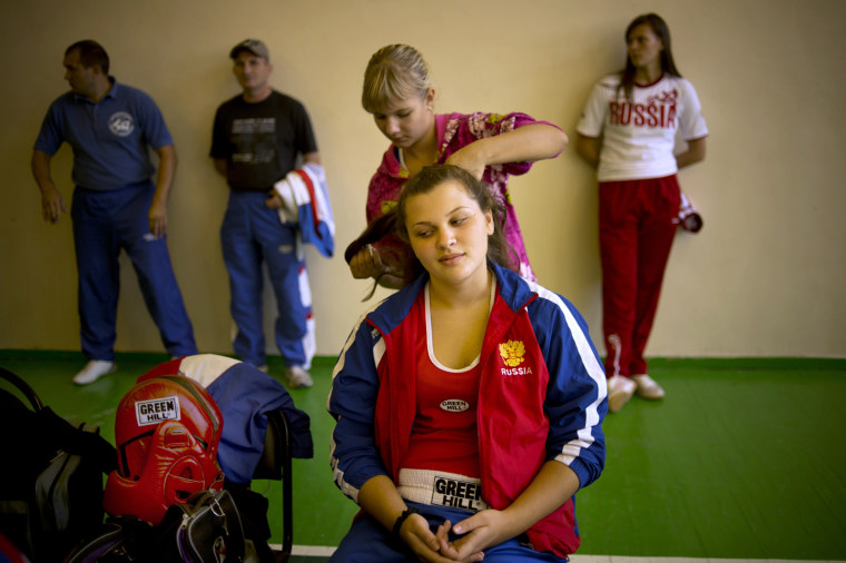 A junior female boxer combs the hair of her fellow boxer before a bout during the All-Russian Women's Junior Boxing Tournament, Aug. 22.