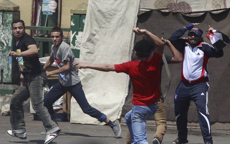 A supporter of Egypt's President Mohamed Mursi, in red, clashes with anti-Mursi protesters during a demonstration in Tahrir Square, Cairo, Aug. 24, 2012.