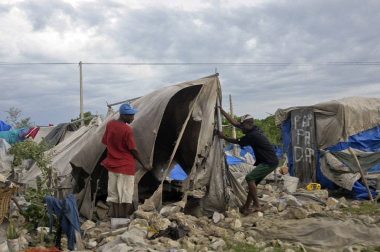 Haitians living in a tent camp built for people affected by the Jan. 2010 earthquake try to repair their tent that was destroyed after Tropical Storm Isaac swept through Port-au-Prince Aug. 26.