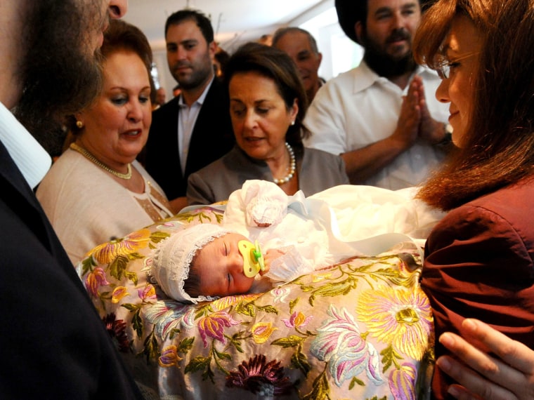 Benjamin Abecassis rests on a pillow surrounded by family members immediately following his bris, a Jewish circumcision ceremony in San Francisco. The nation's top pediatrician's group said the health benefits of procedure outweigh the risks, but stopped short of recommending it.