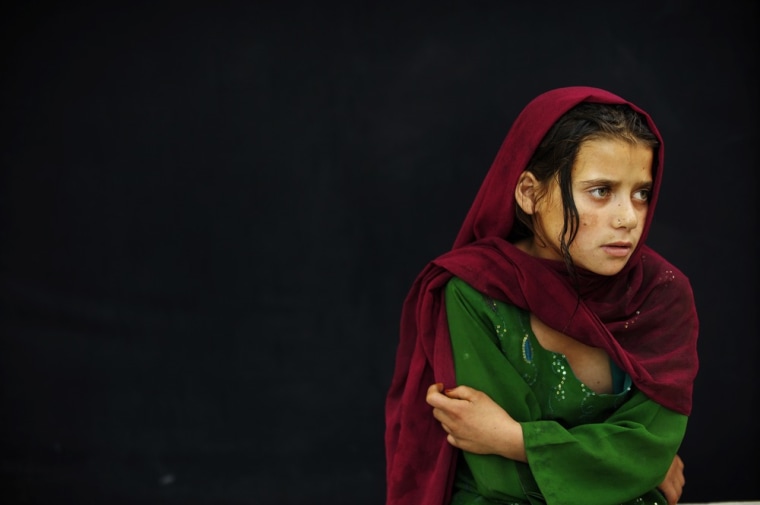 An Afghan girl watches jugglers rehearse at the Juggling Championships in Kabul, Afghanistan.