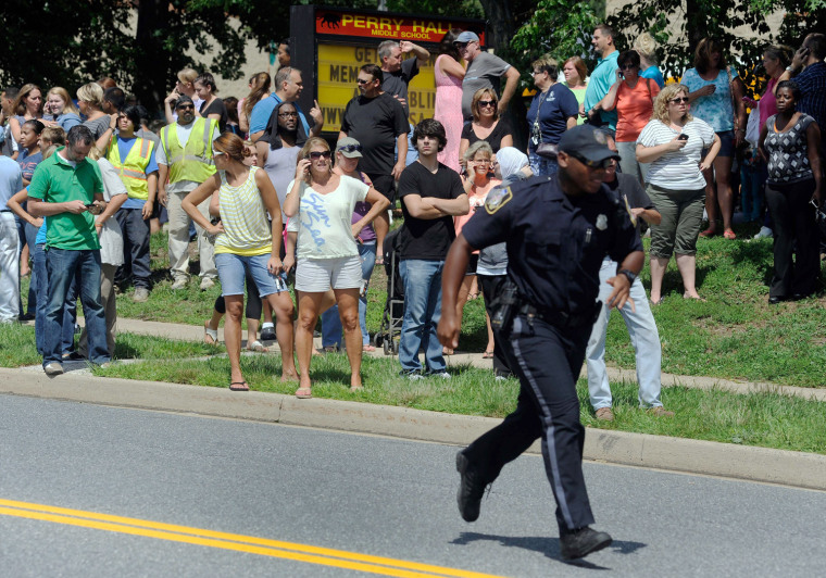 Parents wait to reunite with their children after a student was shot and critically wounded on the first day of classes at Perry Hall High School, Aug. 27, 2012, in Perry Hall, Md.