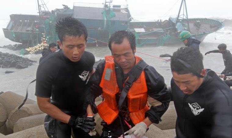 The South Korean coast guard rescue a crew member, center, of a stranded Chinese fishing boat.