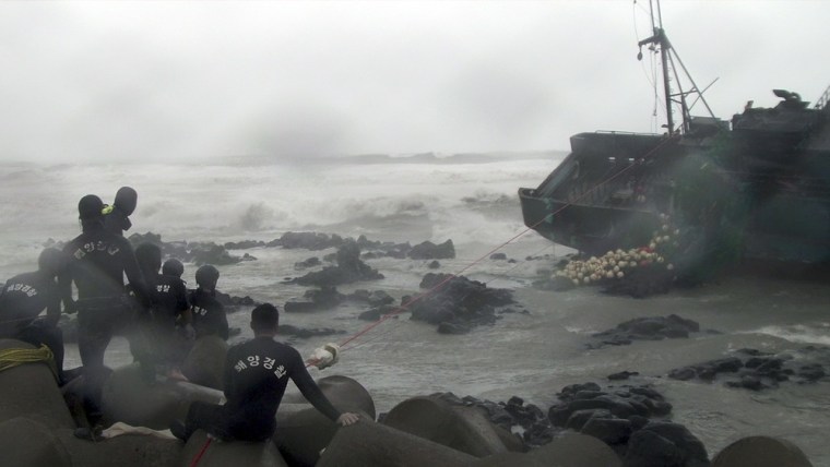 South Korean coast guardsmen attempt to rescue Chinese fishermen after it slammed into rocks off the coast of Jeju, south of Seoul.