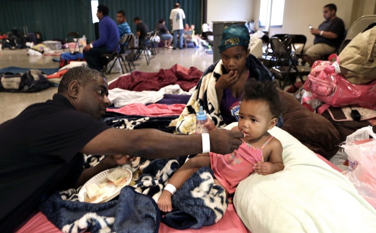 Gus Williams, left, feeds his step-granddaughter Somaya Washington, right, as her mother, Areonisha Washington, center, watches after evacuating to a shelter in Houma, La., Tuesday, on May 28. Forecasters at the National Hurricane Center warned that Isaac, especially if it strikes at high tide, could cause storm surges of up to 12 feet (3.6 meters) along the coasts of southeast Louisiana and Mississippi and up to 6 feet (1.8 meters) as far away as the Florida Panhandle.