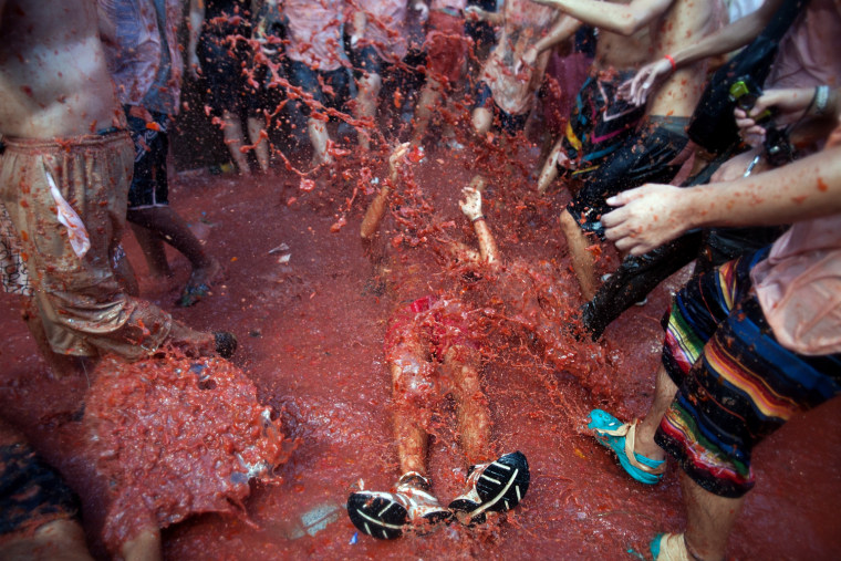 Revellers throw tomato pulp while participating in the annual Tomatina festival on Aug. 29, in Bunol, Spain. An estimated 35,000 people throw 120 tons of ripe tomatoes in the world's biggest tomato fight held annually in this Spanish Mediterranean town.