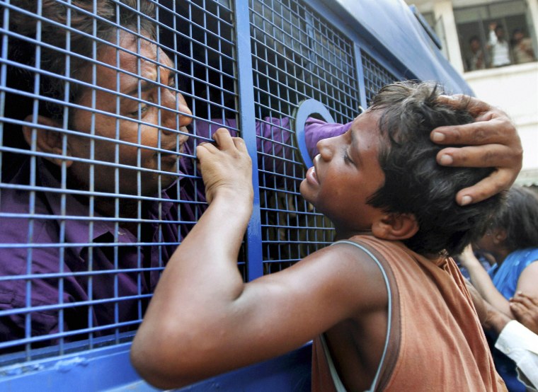 A convict consoles his son while being taken to prison after a court verdict in a 2002 religious violence case, in Ahmadabad, India, Aug. 29, 2012. The court in western India found 32 people guilty of charges ranging from murder to rioting for their part in the deadly religious violence. The religious violence began following a train fire on Feb. 27, 2002, that killed 60 Hindu pilgrims. Muslims were blamed for the fire, leading to weeks of rioting in which Hindu mobs rampaged through towns and villages burning Muslim homes and businesses.