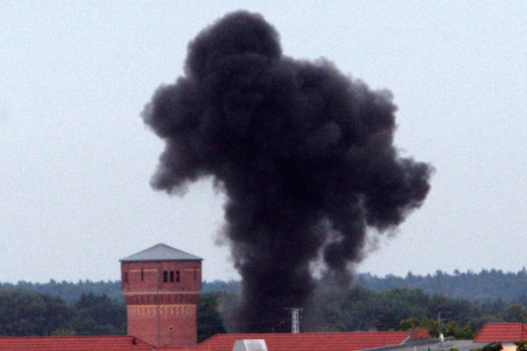 A smoke column rises over the roofs of Oranienburg, Germany, on Aug. 30, 2012, following a controlled blasting of a World War II bomb near the Oranienburg train station.
