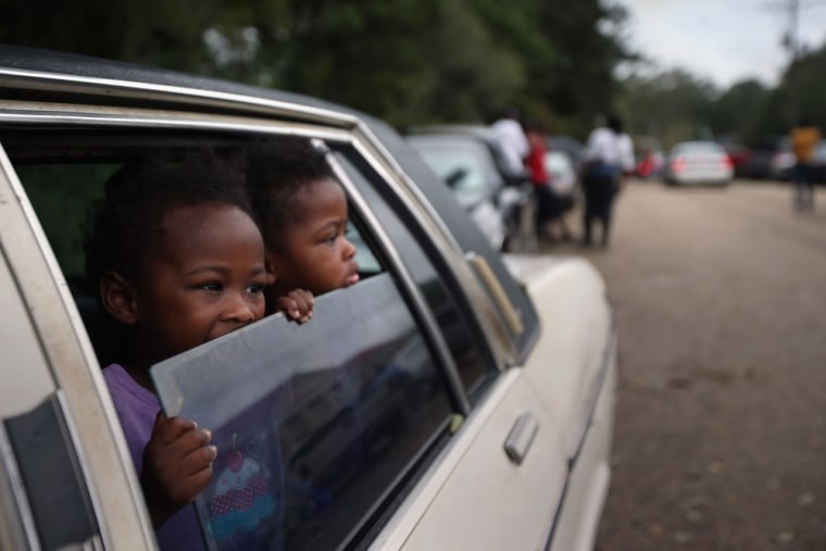 A family fleeing the potential dam break waits to enter a shelter in Kentwood, La., on Thursday.