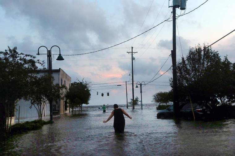 A woman walks through flood waters from Hurricane Isaac storm surge on the north shore of Lake Pontchartrain on August 30, 2012 in Mandeville, Louisiana.