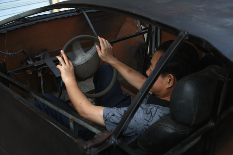 A friend of Wang Jian sits in Wang's homemade Lamborghini replica on August 31, 2012.