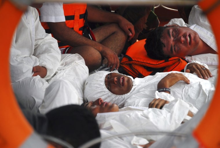 Survivors lie on the deck of a rescue boat upon arrival at a port in Merak on Aug. 31.