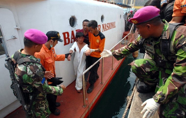 Indonesian rescuers help a young survivor to get back on dry land at Merak seaport, Banten Province, Indonesia, Aug. 31. A boat carrying an estimated 150 migrants en route to Australia sank off Indonesia's Java island on Wednesday.