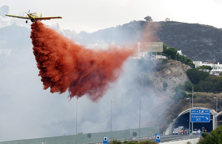 A light aircraft sprays water with an extinguishing agent over a forest fire along a motorway in Calahonda, Malaga, southern Spain, on Aug. 31. Forest fires continue to expand due to the high temperatures and the fanning wind and forced the evacuation of thousands of people in the Sierra Negra (Black Mountains) the day before on 30 August 2012.