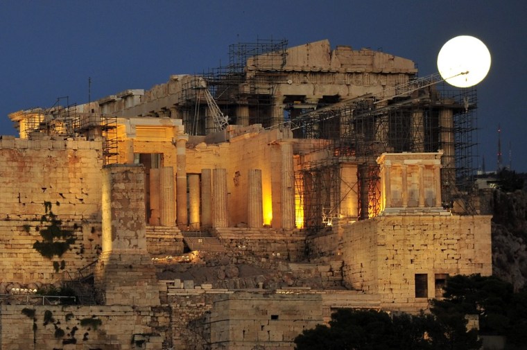 A picture taken on Aug. 31 shows the full moon above the ancient Acropolis hill in Athens.